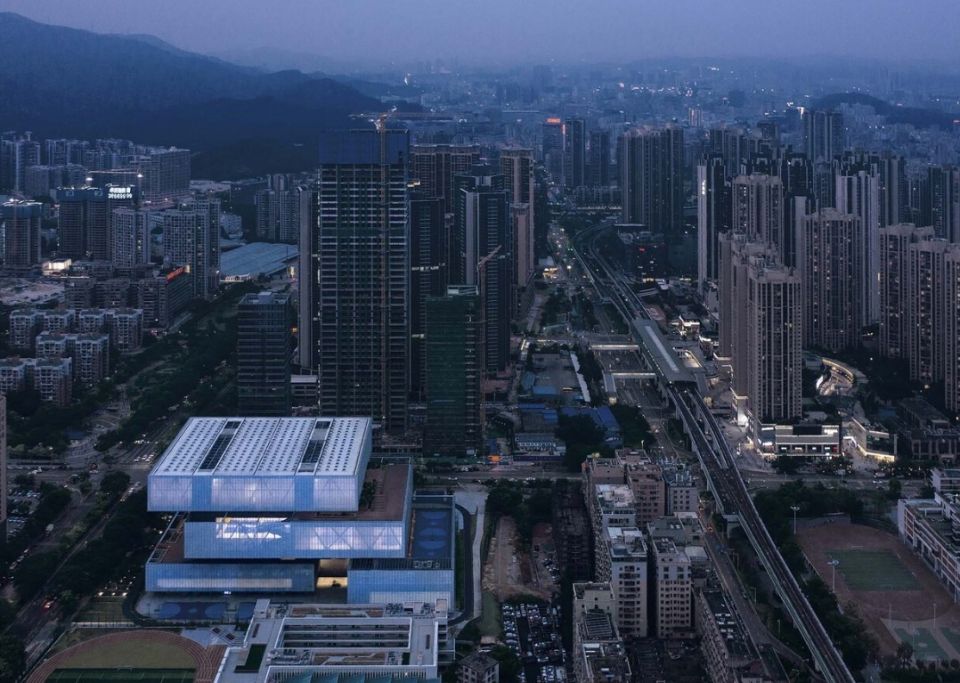 Вертикальный спортивный комплекс ЦзяньшанНеобычный спортивный комплекс вертикального типа "Цзяньшан" построили в Шэньчжэне, Китай, по проекту архитектурной студии Shenzhen Shuimu Architectural Design Co. Огромное здание площадью 65000 м2, состоит из нагромождения прямоугольных объемов, расположенных друг над другом и выступающих впечатляющими консолями.Здание имеет стальной каркас, возведенный вокруг шести железобетонных ядер. Фасад здания - двойной, наружный слой выполнен из алюминиевой сетки, а внутренний представляет энергоэффективное остекление. Интерьеры помещений выполнены в индустриальном стиле, выставляющем строительные конструкции напоказ. Спортивный комплекс включает крытые стадионы, теннисные корты, несколько бассейнов, залы для тренажеров и многое другое. Вертикальное расположение спортивных залов обусловлено ограничением строительной площадки.