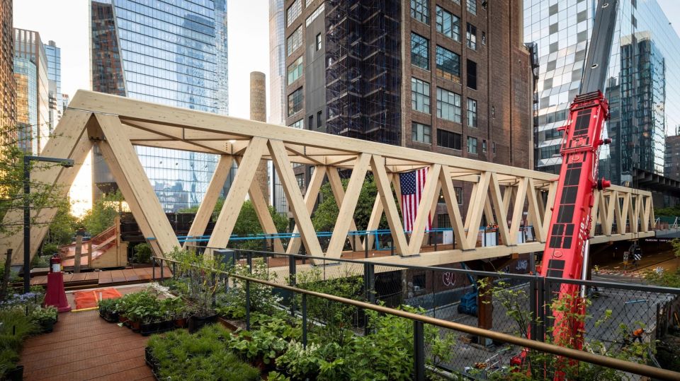 В Нью Йорке дополнили знаменитую эстакаду High Line новым фрагментом из клееной древесиныTimber Bridge - мост из клееной древесины, соединяющий парк High Line, расположенный на бывшей железнодорожной эстакаде, с Пенсильванским вокзалом. Проект разработан архитектурной студией Skidmore, Owings and Merrill (SOM) в сотрудничестве с James Corner Field Operations.128-тонное двухсекционное сооружение, выполненное из бруса Глулам, длиной 92 метра пересекает целый квартал. Деревянные пролетные конструкции опираются на Y-образные стальные пилоны высотой 8 м.
