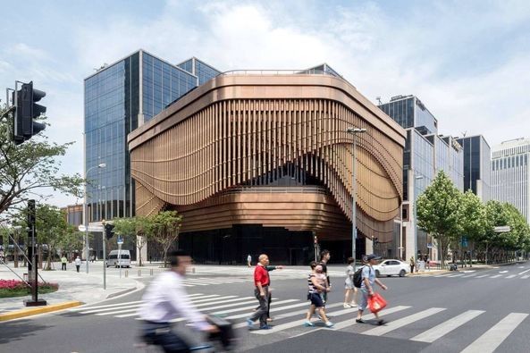 Динамический фасад здания художественного центра в ШанхаеДинамический фасад – главная особенность трехэтажного здания художественного центра Fuson Foundation, возведенного в Шанхае в 2017 году по проекту архитектурных студий Нормана Фостера и Томаса Хизервика.Фасад имеет «вуаль», состоящую 675 бронзовых труб длиной от 2 до 16 метров, расположенных в три слоя и подвешенных вертикально к направляющим карниза. Приводимый в движение специальным механизмом, каждый из слоев «вуали» циклично перемещается в заданном направлении с определенной скоростью. Вследствие этого фасад может иметь различные степени прозрачности – от полностью закрытого до частично открытого.На 4000 квадратных метров центра размещены многофункциональные общественные пространства, предназначенные для выставок, встреч, выступлений и форумов.#фасады #китай