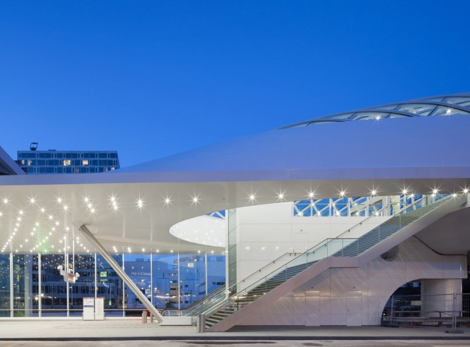 Lightrailstation - железнодорожный вокзал в Гааге (Нидерланды)Новый городской железнодорожный вокзал в голландском городе Гааге решен в легких и светлых металлических конструкциях. Объект состоит из повышенного железнодорожного пути на эстакаде с двумя ветками пригородных монорельсов и здания зала ожидания. Железнодорожная эстакада с посадочными площадками имеет скульптурный внешний вид и, по мнению разработчиков проекта, архитектурной студии ZJA, органично вписывается в городской контекст.Параметрический навес эстакады является главной особенностью проекта и предметом гордости архитекторов. Его динамичная форма является не дизайнерским изыском, а результатом математического моделирования, направленного на получение наиболее экономичной с точки зрения материалоемкости конструкции. Навес имеет двойное остекление из многослойных панелей прямоугольной формы, изогнутых методом холодного гиба.