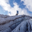 Экстремальный приют для альпинистов на вершине КанинВ Юлианских Альпах, расположенных на границе Италии и Словении, на вершине горы Канин в 2016 году построен небольшой приют, в котором можно провести ночь в относительно комфортных условиях.Конструкция, спроектированная архитектурной студией Любляны OFIS Arhitekti (Словения), доставлена на вершину вертолетом по частям. Сооружение установлено в положении, которое кажется со стороны неустойчивым, и надежно раскреплено растяжками.Постройка выполнена из дерева, обшитого алюминиевыми листами. Большие окна открывают захватывающий вид на величественные суровые Альпы. Сам домик состоит из небольшого холла, гостиной и места для отдыха. Одновременно там может поместиться до девяти человек.